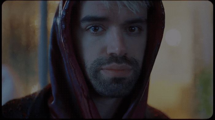 a man wearing a hoodie stares into the camera