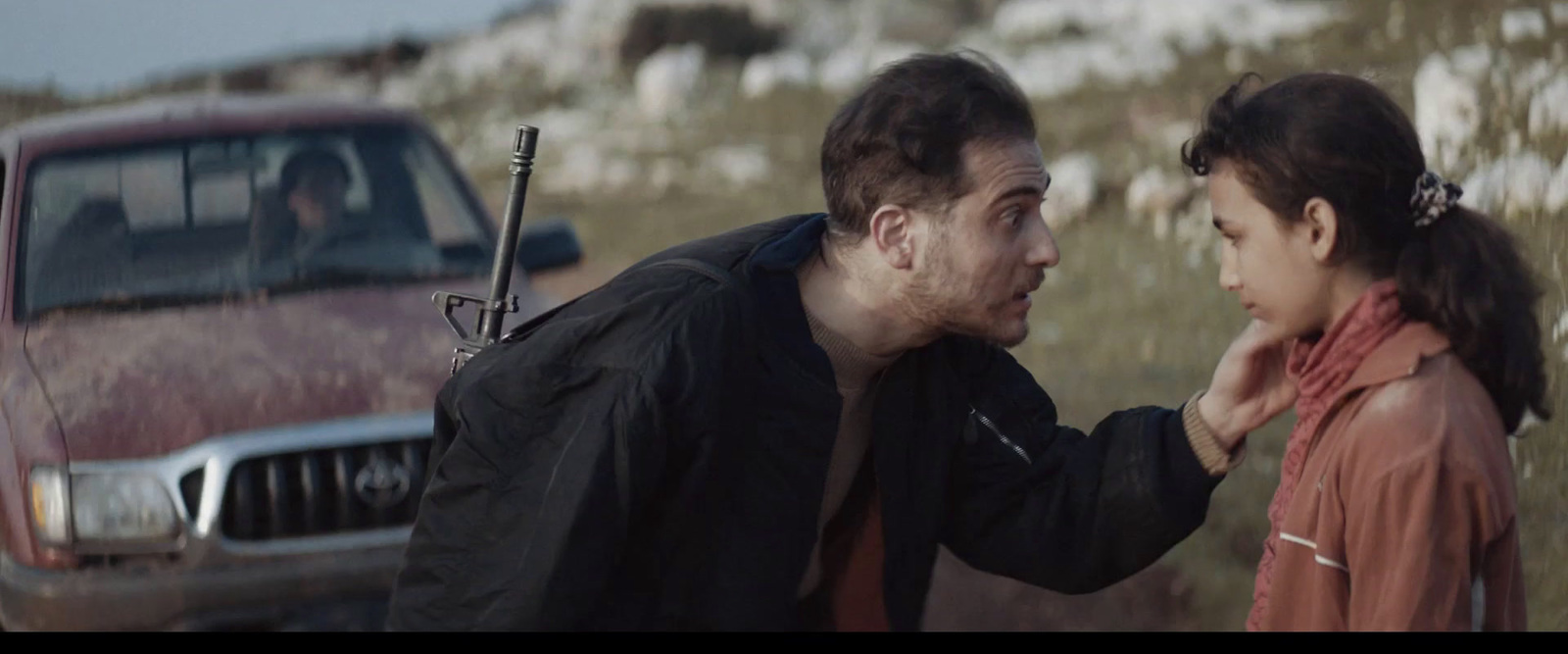 a man standing next to a woman near a truck