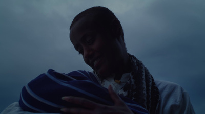 a man with dreadlocks holding a blue blanket