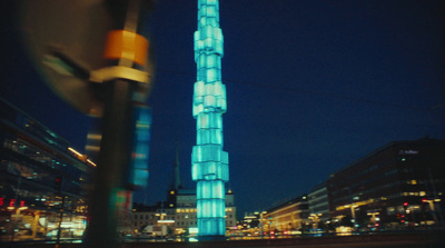 a tall building lit up at night in a city