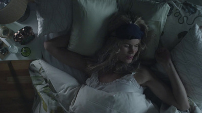 a woman laying in bed with a headband on