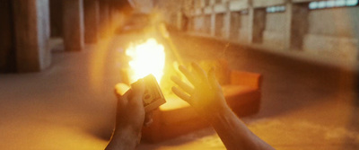 a person holding a cell phone in front of a fire