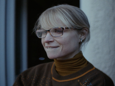 a woman wearing glasses and a turtle neck sweater