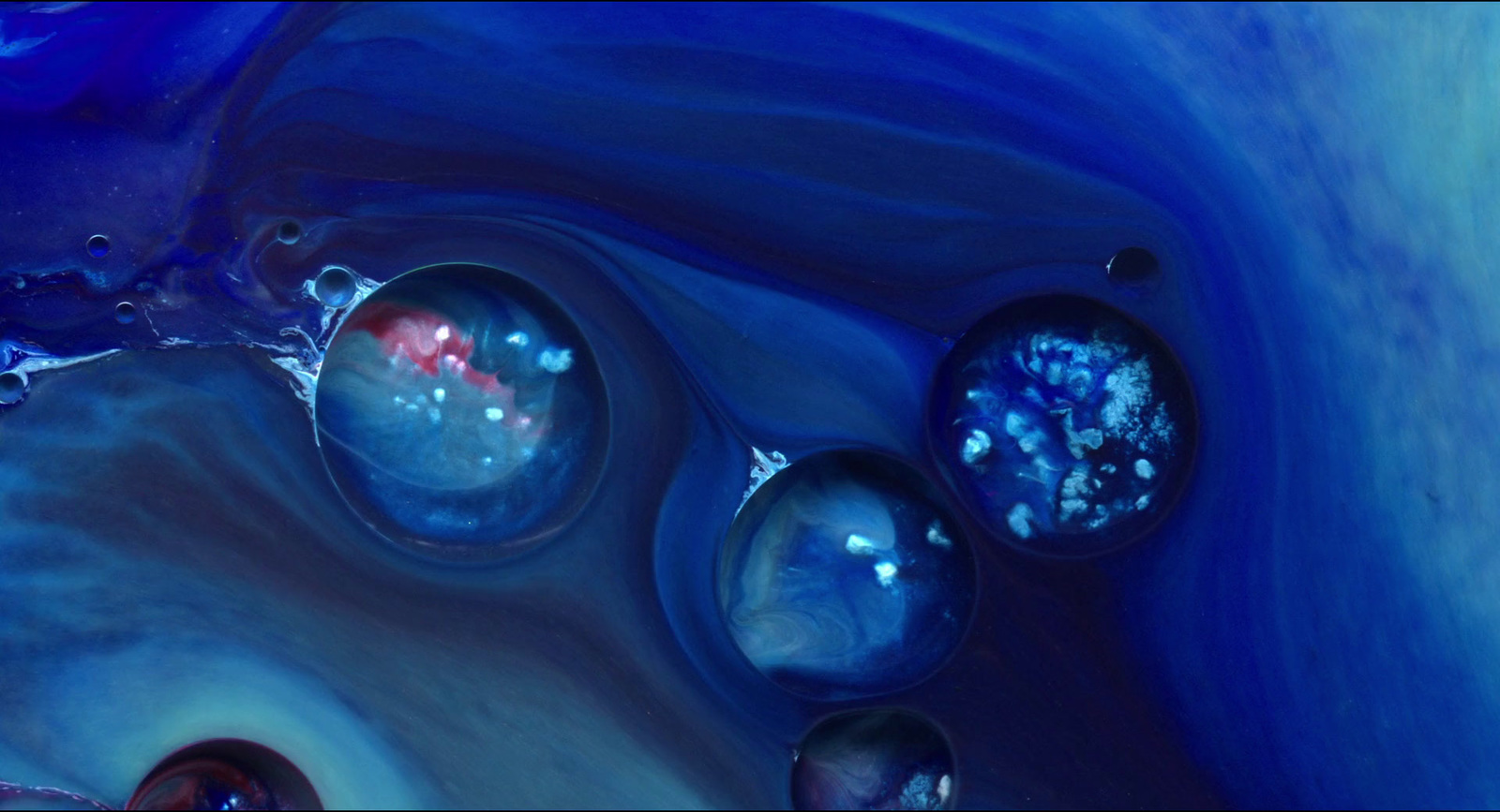 a close up of some water bubbles in a blue liquid