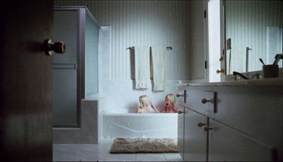 two girls sitting in a bathtub in a bathroom