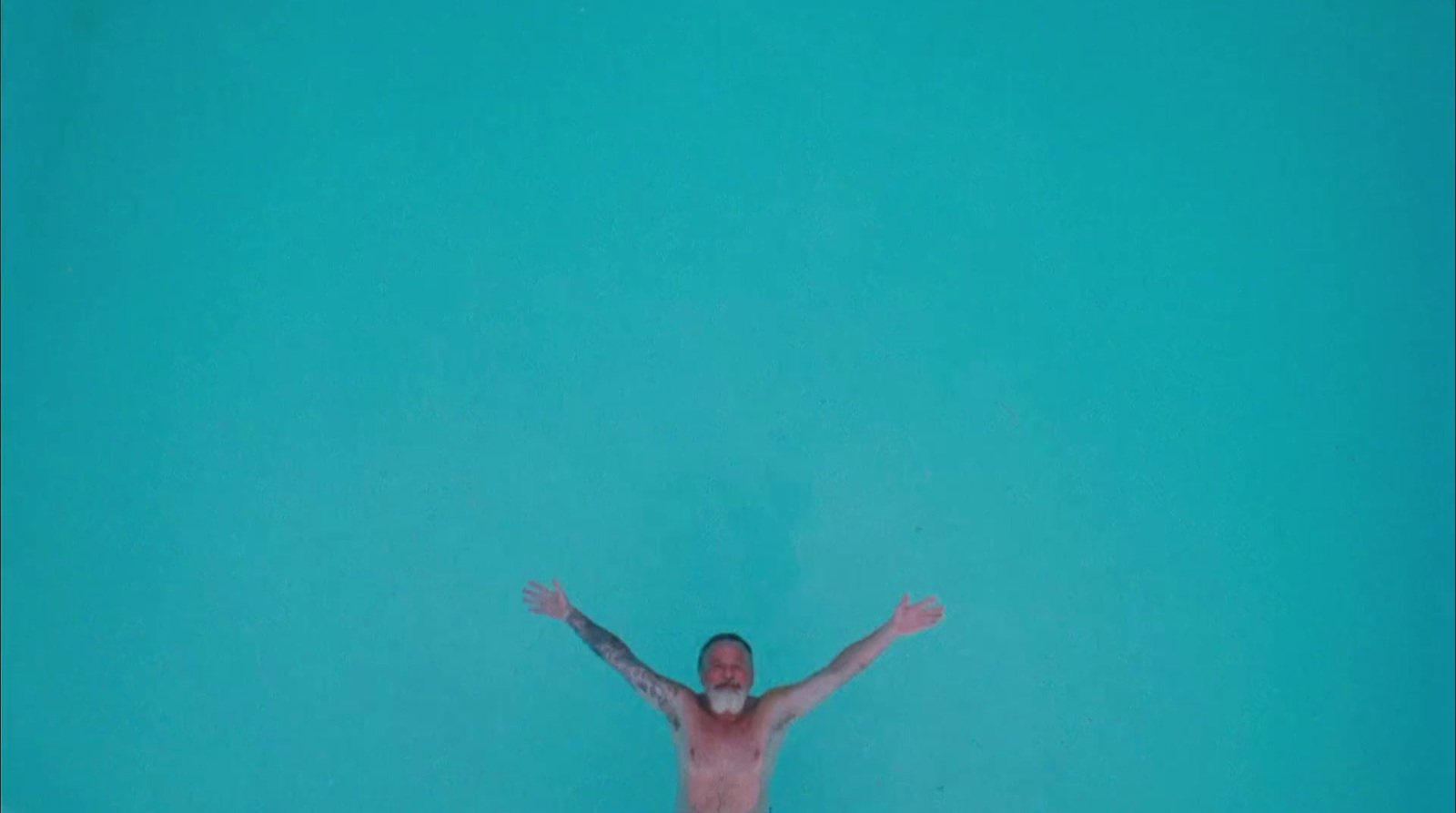 a man standing in the water with his arms outstretched