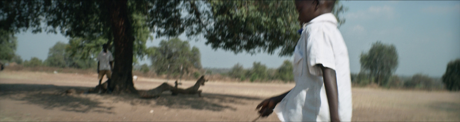 a man in a white shirt is walking in a field