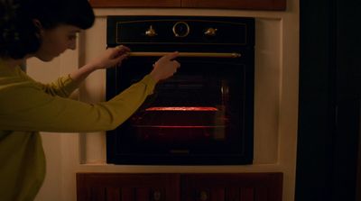 a woman is putting something in an oven