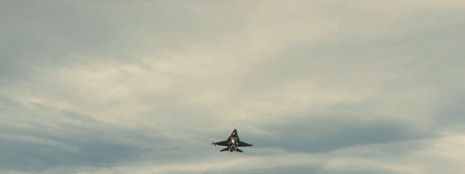 a fighter jet flying through a cloudy sky