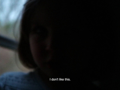 a girl looking out a window with a sad look on her face