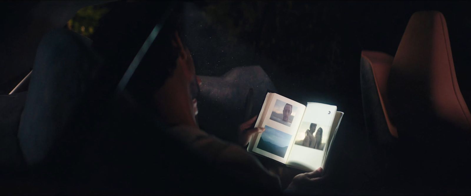 a person sitting in a car reading a book