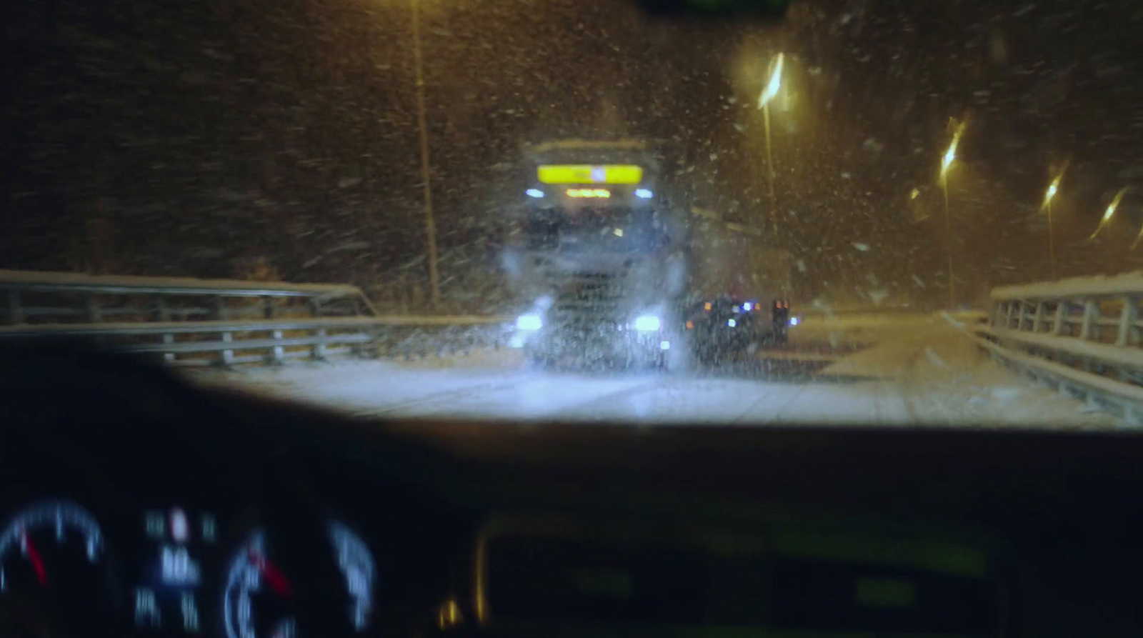 a car driving down a snowy road at night