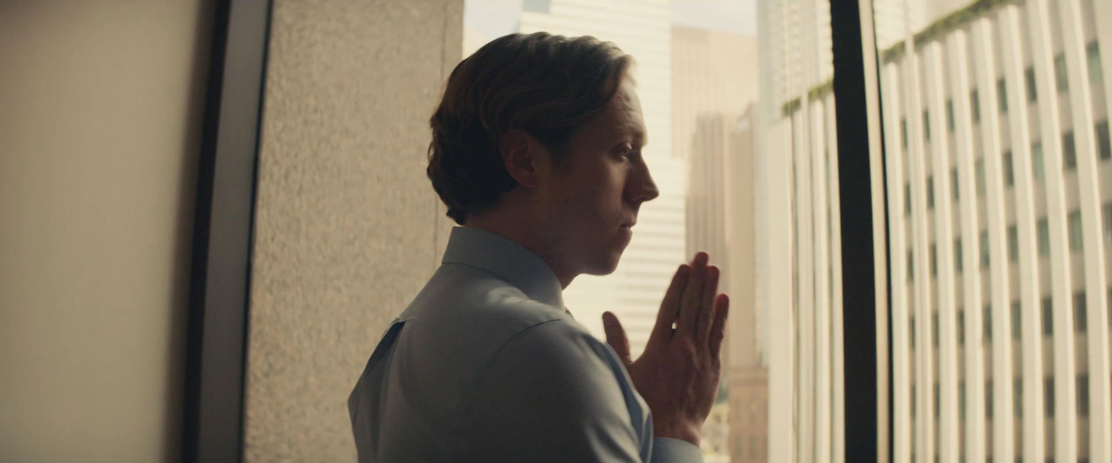 a man standing in front of a window praying