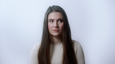 a woman with long hair is looking at the camera