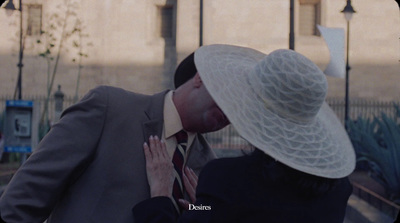 a man and a woman kissing in front of a building