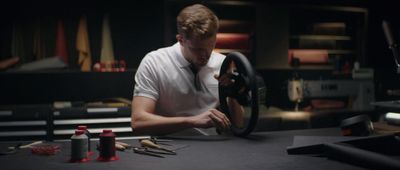 a man sitting at a table with a steering wheel