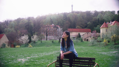 a woman sitting on top of a wooden bench