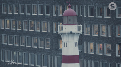 a white and red lighthouse in front of a building