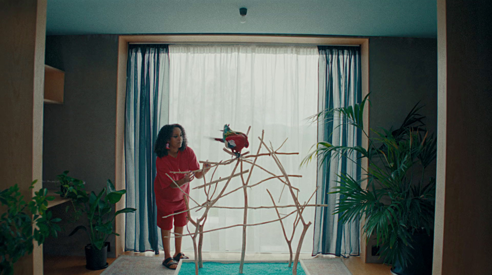 a little girl standing in front of a sculpture of birds