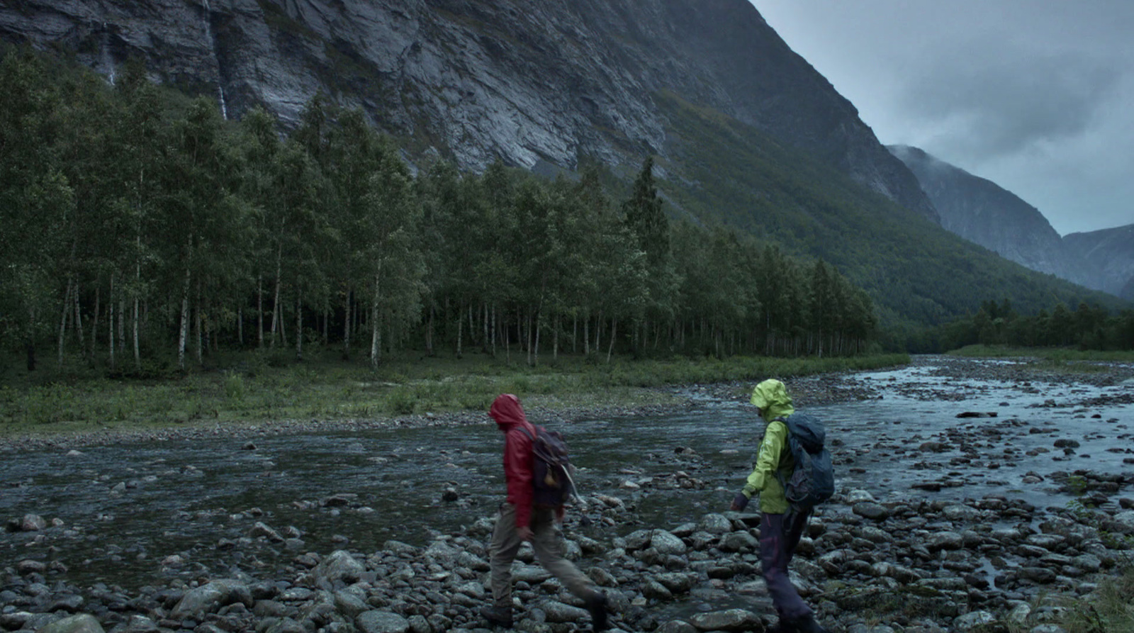 a couple of people walking across a river