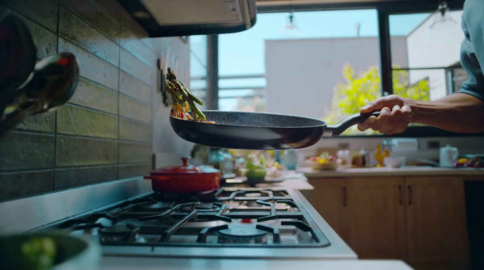 a man is frying food in a wok on the stove