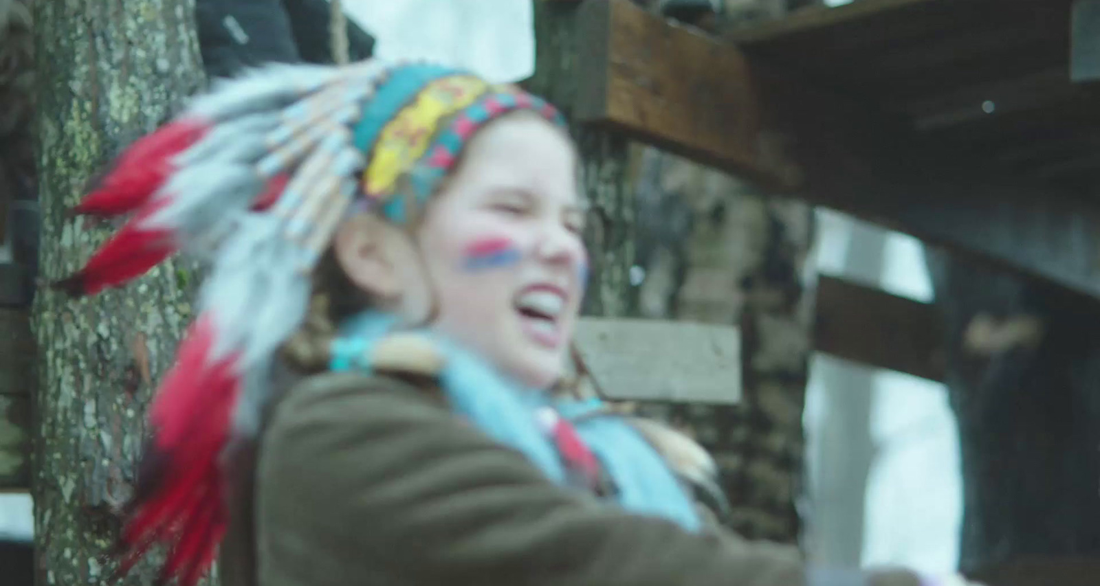 a young girl wearing a colorful headdress and feathers