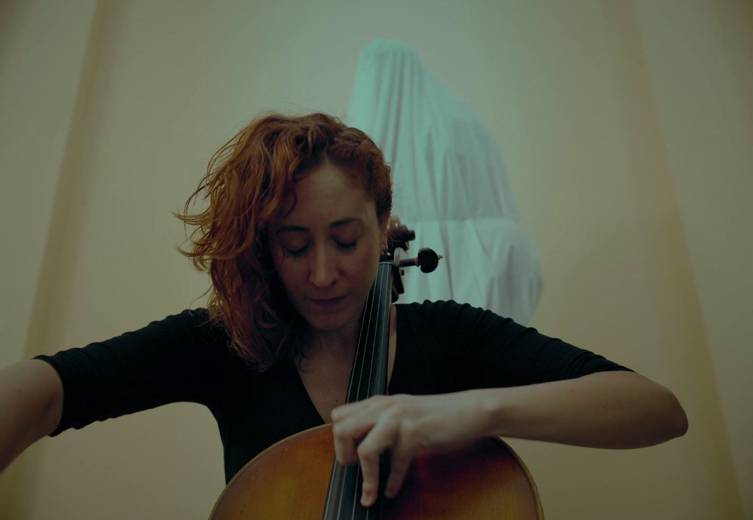 a woman playing a cello in a room