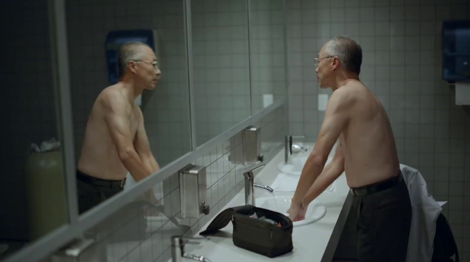 a man standing in front of a mirror in a bathroom