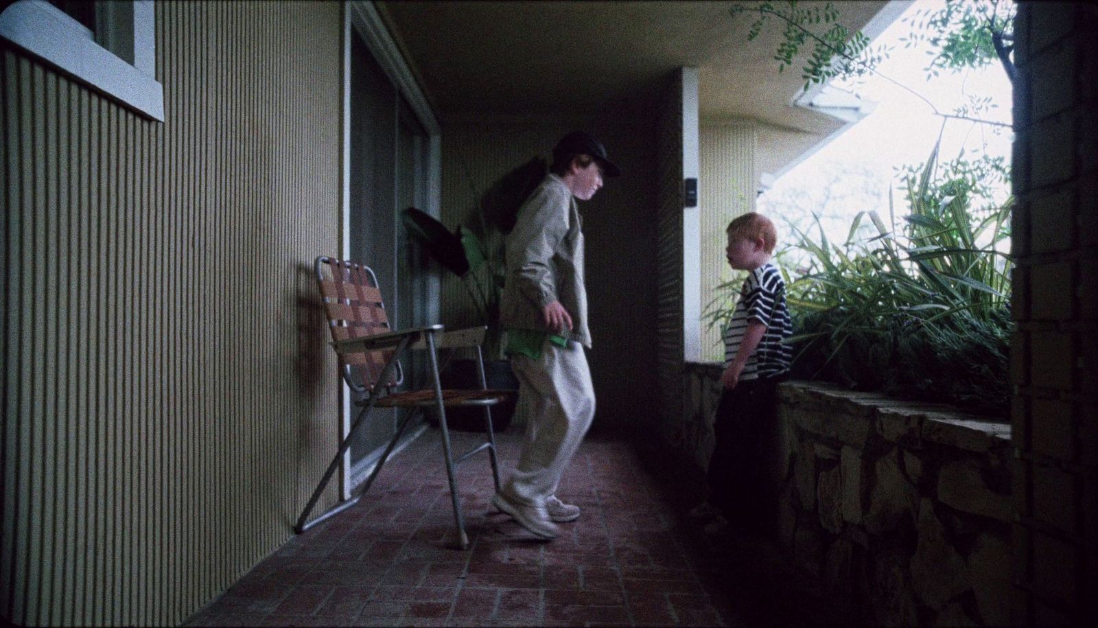 a man standing next to a little boy on a porch