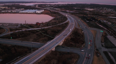 an aerial view of a highway with a lake in the background