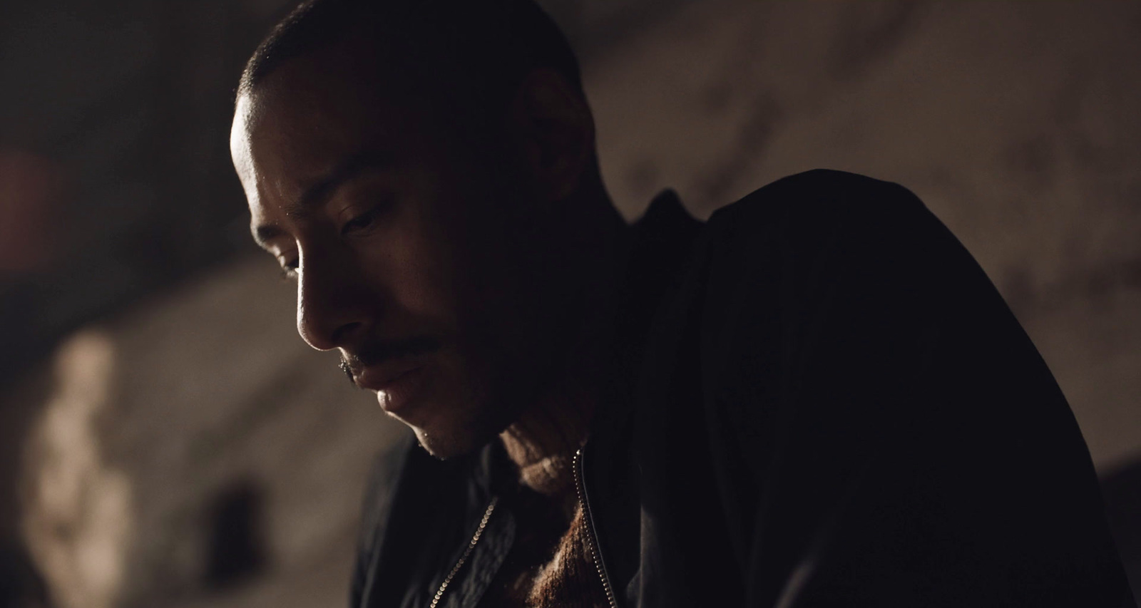 a man in a dark room looking at his cell phone