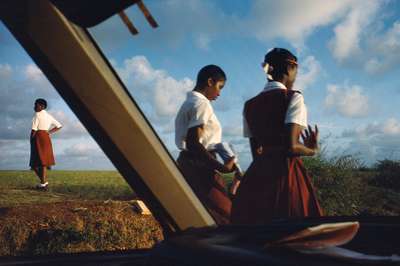 a group of people standing on top of a lush green field