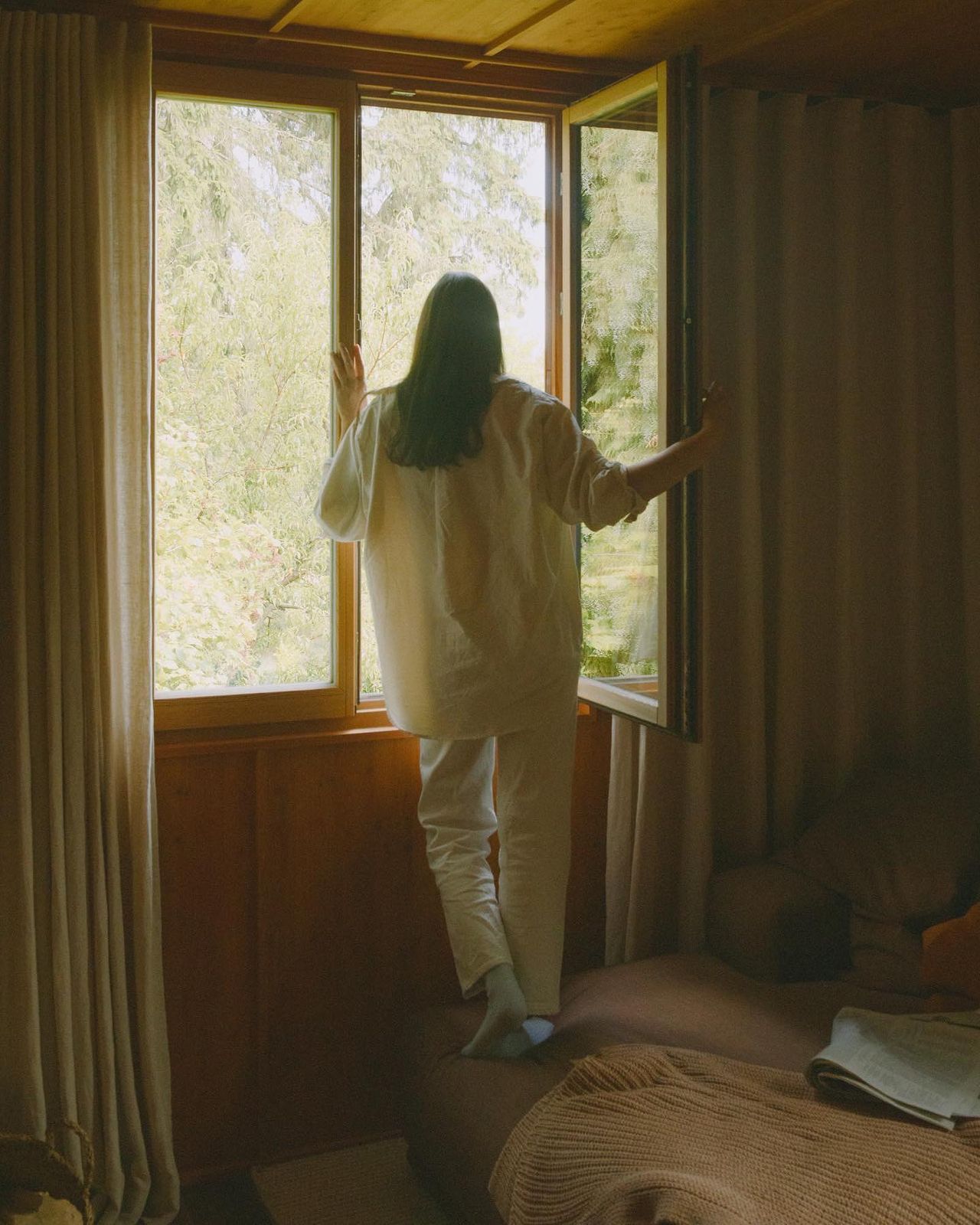 a woman standing in front of a window