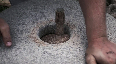 a man is holding a stone with a wooden stick sticking out of it