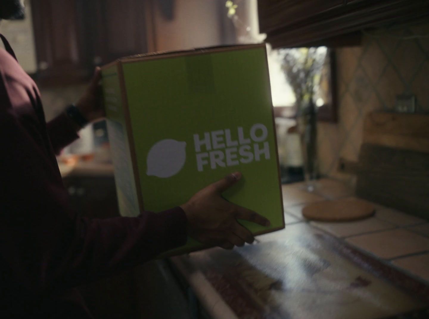 a person holding a box that says hello fresh