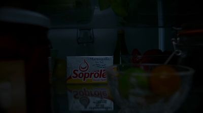 a box of soup sits on a counter next to a bowl of fruit