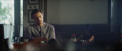 a man sitting at a table looking at his cell phone