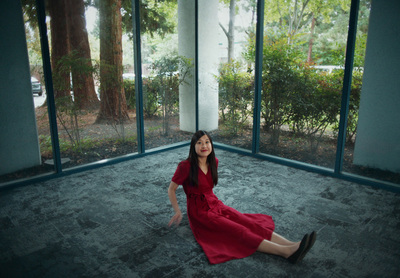 a woman in a red dress sitting on the floor