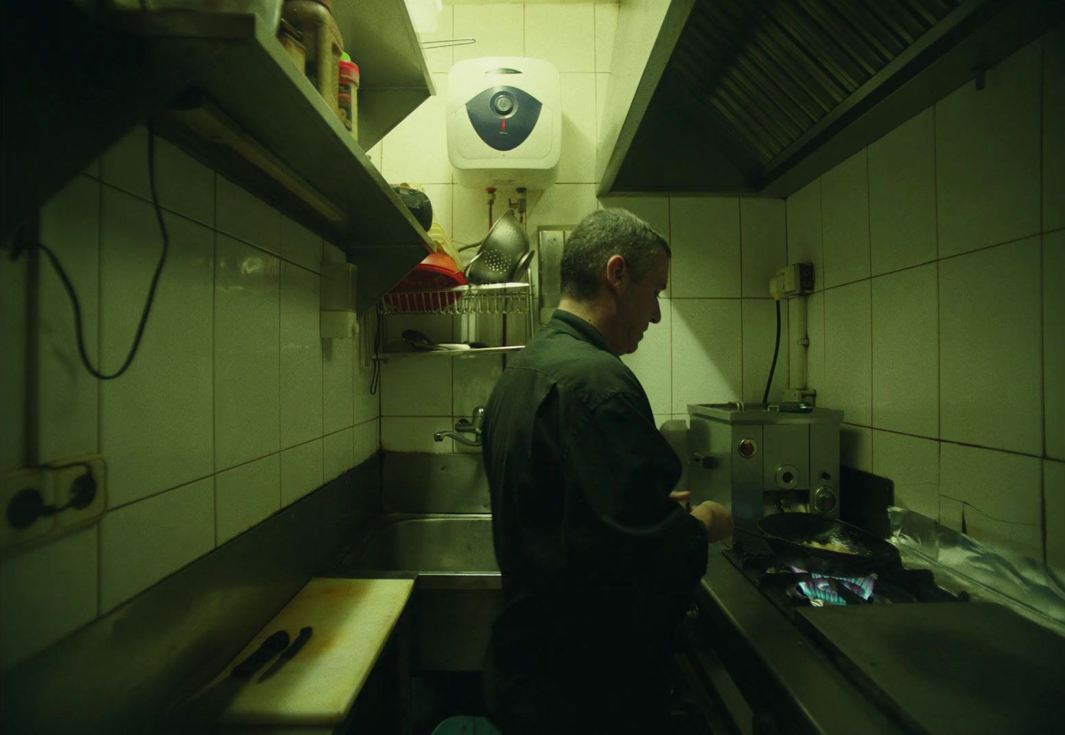 a man standing in a kitchen next to a sink