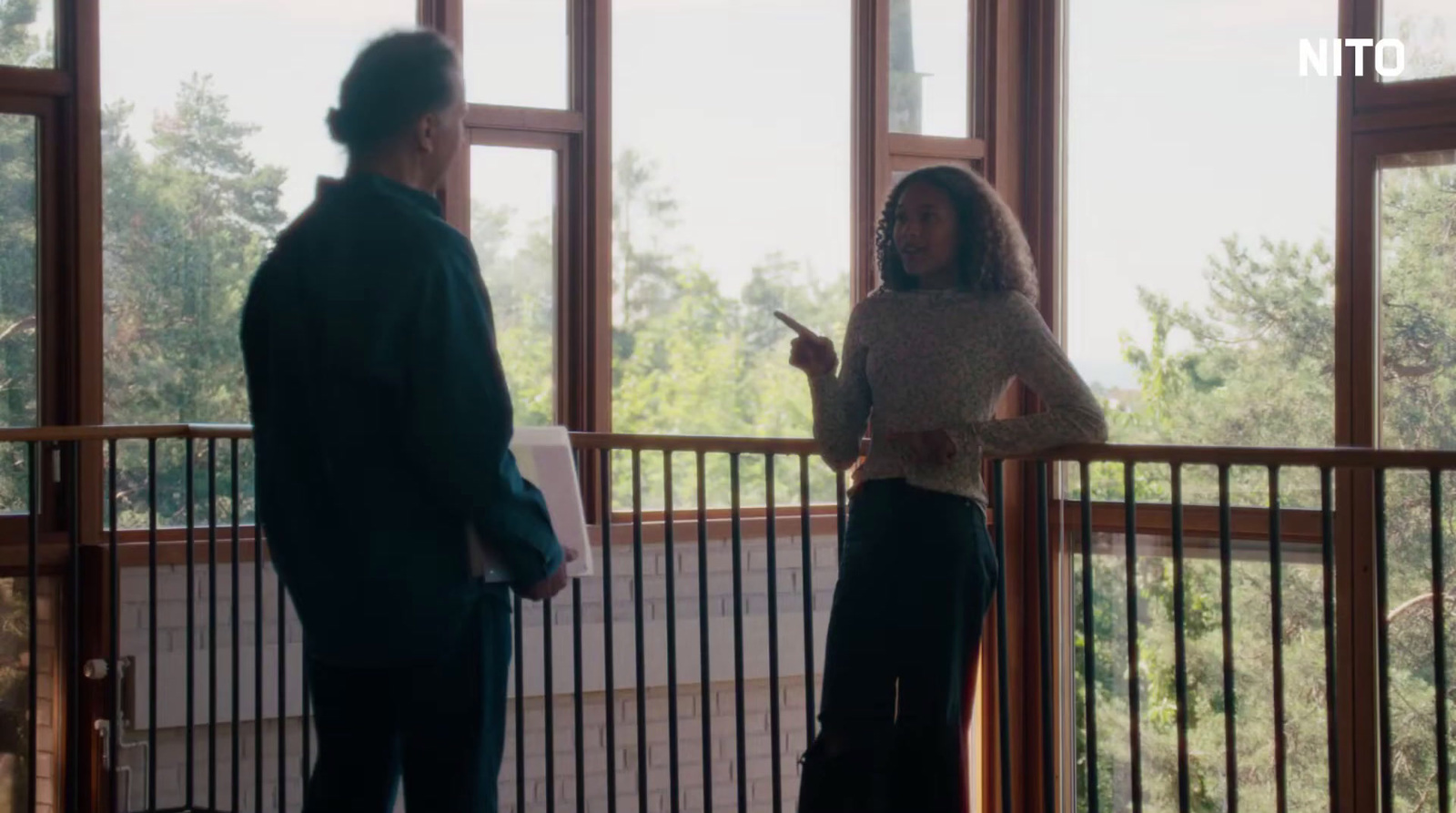 a woman standing next to a man on a balcony