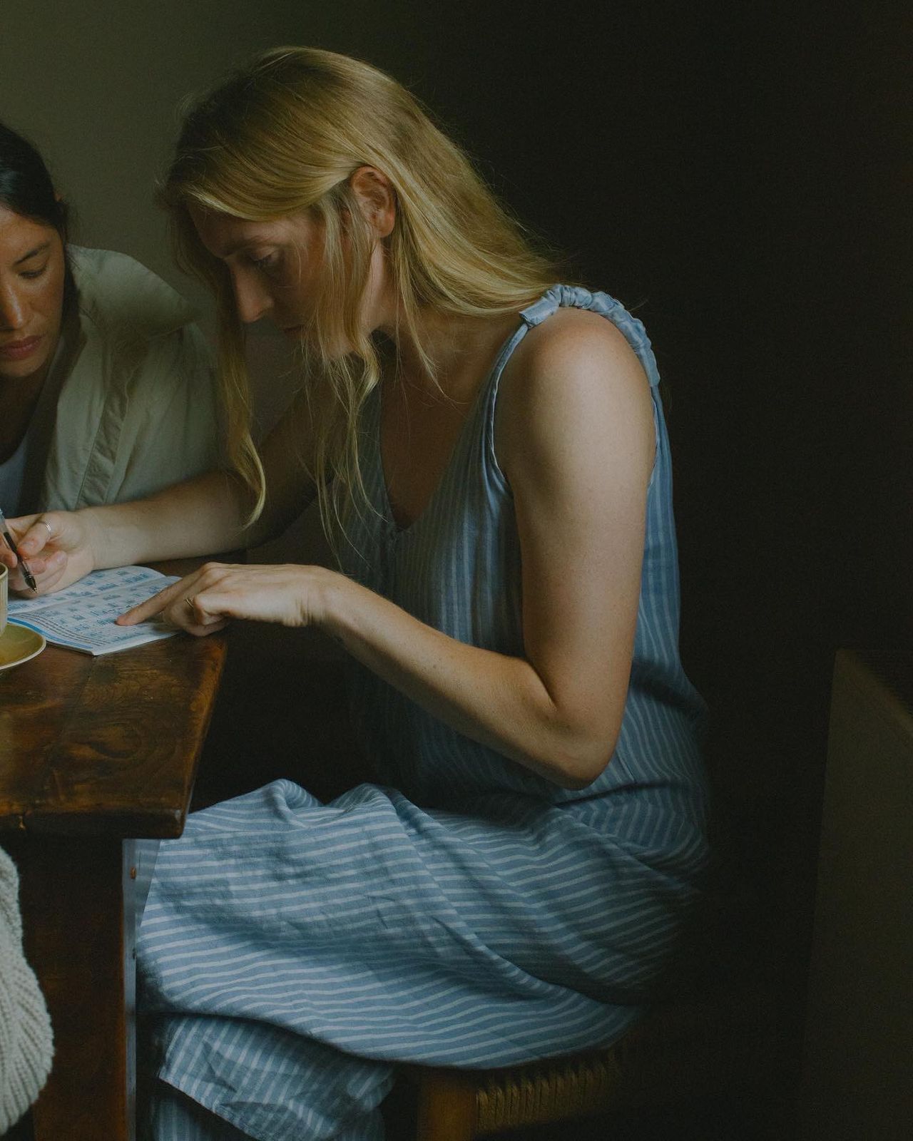 a man and a woman sitting at a table writing