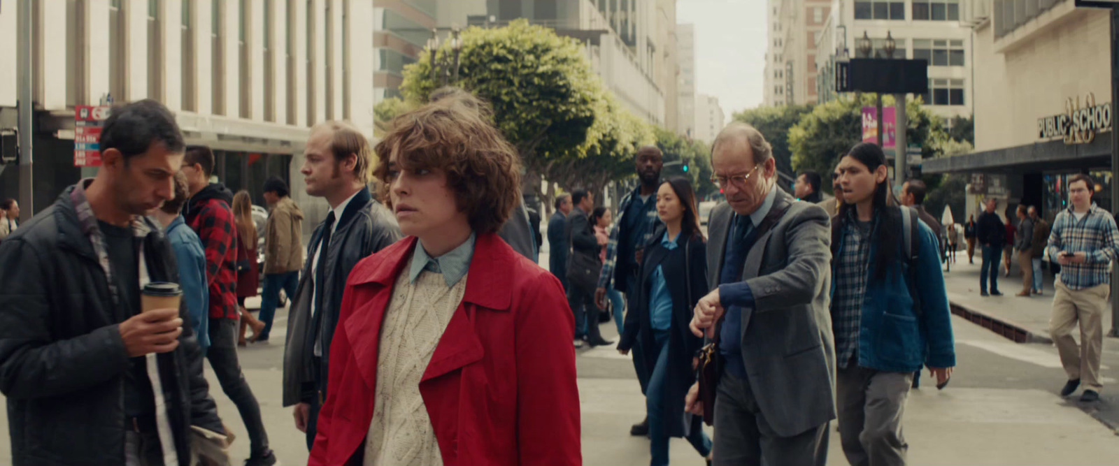 a group of people walking down a street next to tall buildings