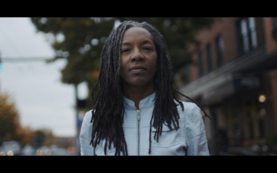 a woman with dreadlocks standing on a city street