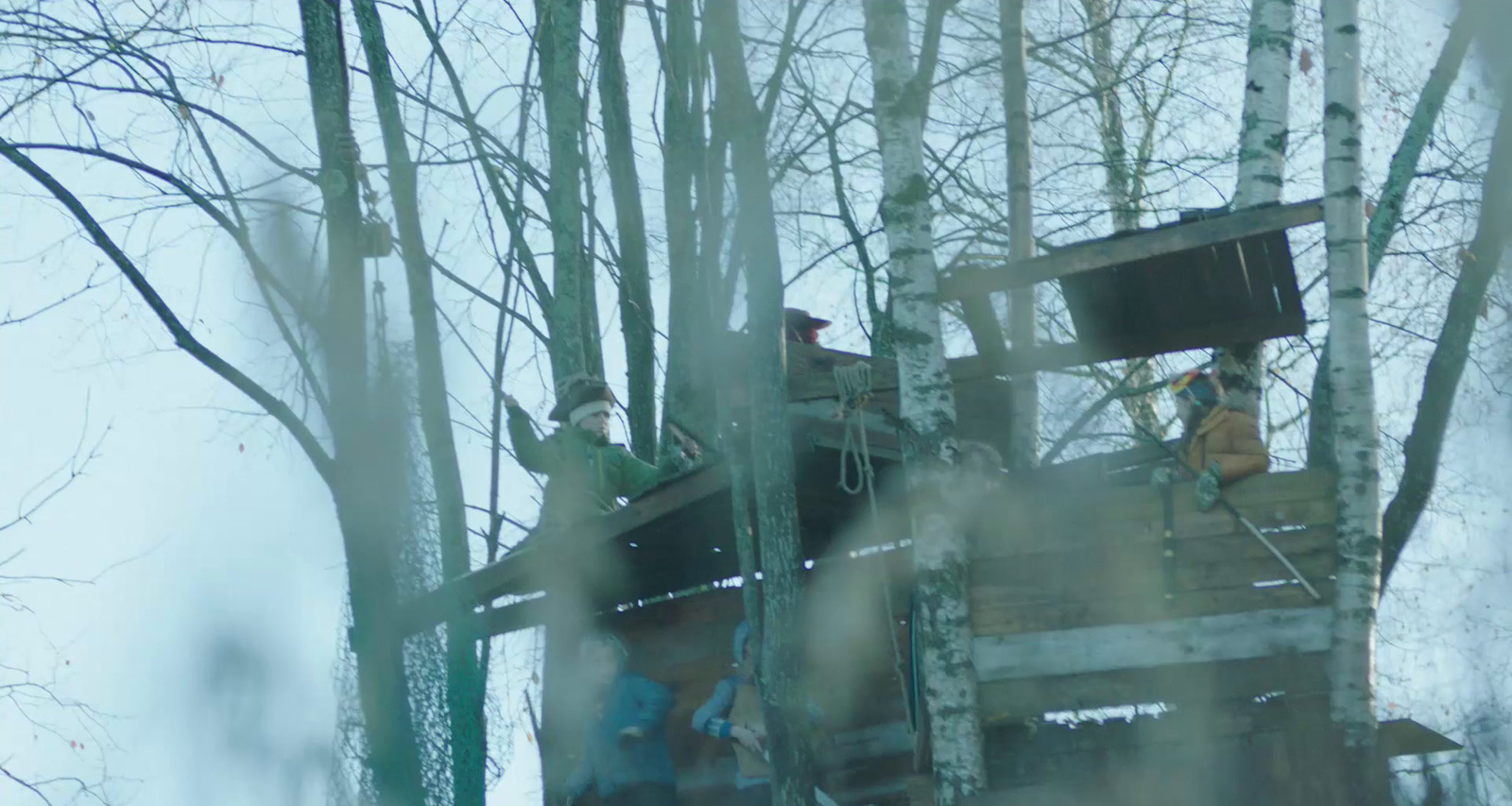 a couple of men standing on top of a wooden structure