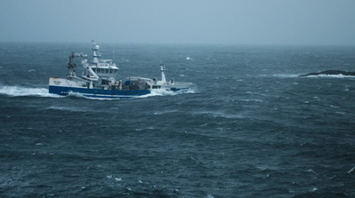 a blue and white boat in the middle of the ocean