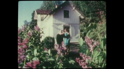 a couple of people standing outside of a house