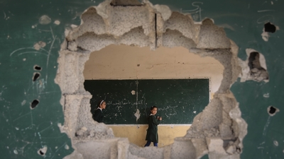 a hole in a wall with a man standing next to it