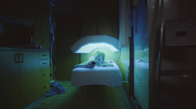 a person laying in a bed in a dark room