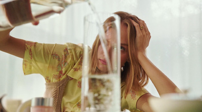 a woman sitting at a table with a glass of wine