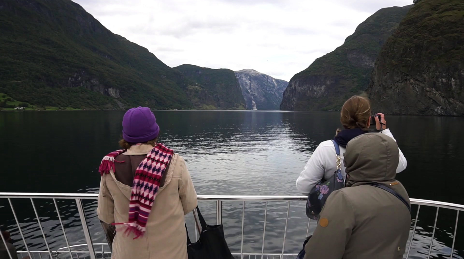 a group of people on a boat looking out over a body of water